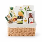 Wicker basket filled with Doi Kham products: tea, drinks, spreads, ketchup, and fruit snacks.