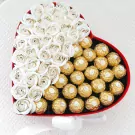 Heart-shaped box with white roses and Ferrero Rocher chocolates, tied with a white ribbon.