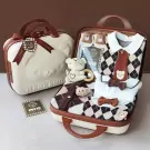 Baby gift set in a suitcase: bear outfit, plush toy, and booties.