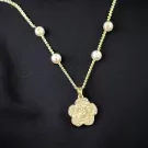 Gold chain necklace with pearl accents and a diamond-encrusted flower pendant.