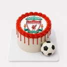 Liverpool FC themed cake with crest and football topper on a white cake board.