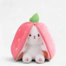 White plush rabbit wearing a pink strawberry costume with a green leaf on top.