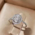 1-carat oval-cut moissanite diamond ring with halo on white gold plated sterling silver band.