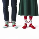 Feet of a couple wearing Christmas socks that magnetically connect.