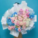 An grand fresh bouquet featuring a dreamy blend of serene blue hydrangeas and pastel pink roses.