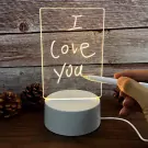 A clear lamp with "I love you" written on it in white, lit from a white base.