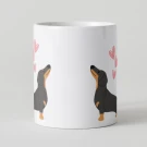 White mug with two black and tan dachshund illustrations and pink hearts.