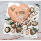 Heart-shaped smash cake with chocolate-dipped strawberries and candies.