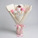 Crochet graduation bouquet with a teddy bear, pink flowers, and a pink ribbon on a white background.