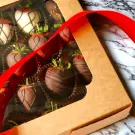 Box of 25 chocolate-covered strawberries, some with white chocolate drizzle and dark chocolate stripes.