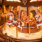 A wooden carousel with painted horses, deer, and ornate details.