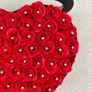 Heart-shaped box filled with red roses, each with a diamond accent.