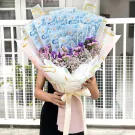 A bouquet of dried flowers with transparent money holders, tied with a peach ribbon.