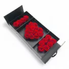 Black keepsake box filled with red roses arranged in an "I LOVE YOU" shape.