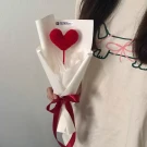 Crocheted red heart bouquet wrapped in white paper with a red ribbon.