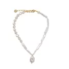 A gold necklace with irregular freshwater pearls, featuring a teardrop pearl pendant.