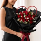 18 fresh red roses, fresh white baby's breath fillers, a handmade heart-shaped twig frame
