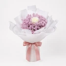 Bouquet of pink limonium with one white rose, wrapped in white paper and tied with a red bow.
