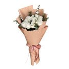 Bouquet of 12 white roses and eucalyptus leaves wrapped in brown paper, tied with a pink ribbon.
