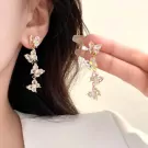Gold drop earrings with three clear zircon butterflies cascading downwards.