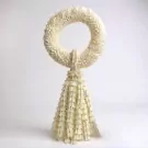 Jasmine garland with a circular top and a tassel of white flowers against a white background.
