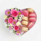 Heart-shaped box with pink roses, daisies, and pink and vanilla macarons.