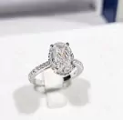 Oval-cut moissanite diamond ring with paved band, set in white gold plated 925 sterling silver.