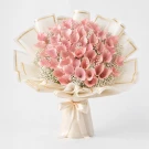 Woman holding a large bouquet of pink flowers made of folded banknotes.
