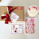 Valentine's gift box with candle, board game, and postcard.