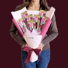 Hershey's chocolate bar bouquet with pink and maroon wrapping, tied with a maroon bow.