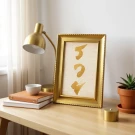 Gold framed art with "Rich" in gold Thai calligraphy on a marble background.