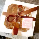 Chocolate chip cookie gift box tied with a brown ribbon, featuring a "Thank You!" tag and cookie assortment.