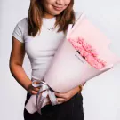 Woman holding a pink flower bouquet with 'flowerstore.ph' sticker and grey ribbon.