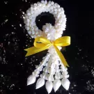White jasmine malai garland with yellow bow against a dark, speckled background.