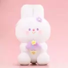 Cute white rabbit plushie holding a purple ice cream cone with a flower on its head.