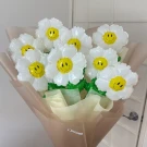 Daisy balloon bouquet with smiley faces in white and yellow, wrapped in brown and cream paper.