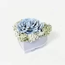 Heart-shaped box with a blue rose made of money and white baby's breath flowers.
