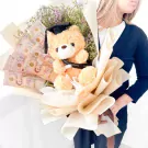 Graduation teddy bear in a bouquet with Thai baht bills and flowers.