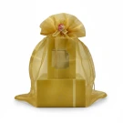 Gold organza gift bag with a decorative rose, containing a stacked set of golden boxes.