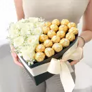 Heart-shaped box with white roses and Ferrero Rocher chocolates.