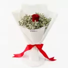 A single red rose surrounded by white limonium, wrapped in white paper and tied with a red ribbon.
