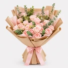 Bouquet of 24 pink roses with eucalyptus, wrapped in brown paper and tied with a pink ribbon.