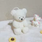 White fluffy bear candle with smaller bears and a sunflower candle.
