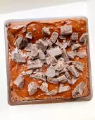 Decadent brownie topped with glossy dark chocolate and generous chunks of dark chocolate.