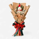 A Christmas bouquet with a snowman decoration, white flowers, pine sprigs, and a festive ribbon.