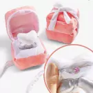 Pink plush ring box with an open lid, revealing a white plush ring, with a separate pink plush box tied with a white ribbon.