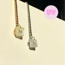 Gold and silver bracelets with UV color-changing square charms with letters M and N.