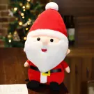 Plush Santa Claus with red hat and suit, white beard, sitting on a wooden table.