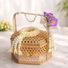 Woven bamboo basket with jasmine garland and purple flowers, decorated for Songkran.