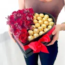Heart-shaped box with red roses and Ferrero Rocher chocolates, tied with a red ribbon.